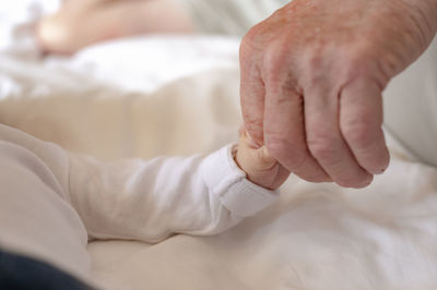 Close-up of grandparent holding toddler hand