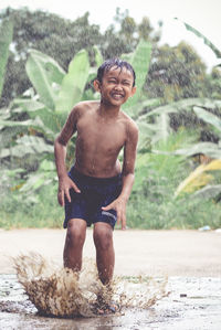 Full length of shirtless man standing in water