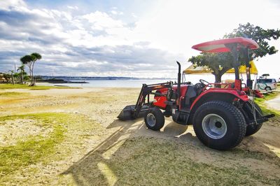 Tractor on beach against sky