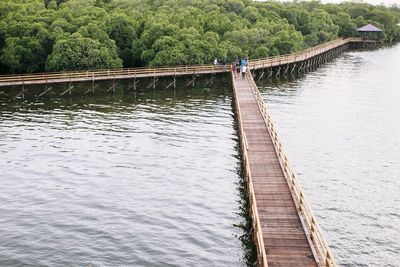 Footbridge over river against sky