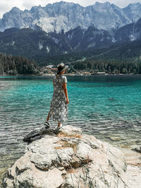 Woman standing on rock by mountain