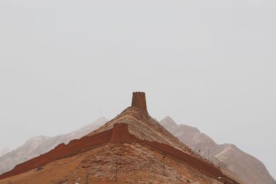 Low angle view of castle on mountain against sky