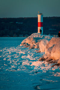 Tourist enjoying a winter sunset at the light house in petoskey michigan