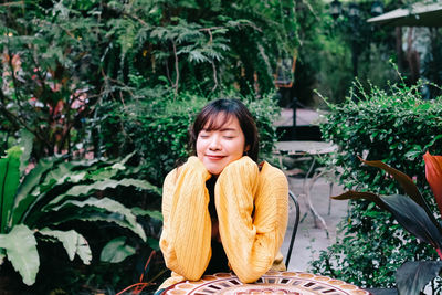 Portrait of smiling young woman sitting outdoors