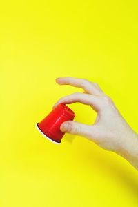 Close-up of hand holding red over white background
