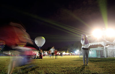 People standing in field at night