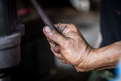Cropped hand of manual worker holding machinery