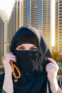 Islamic woman on the background of tall modern business buildings.