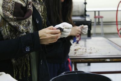 Midsection of two women holding chemical while standing at laboratory