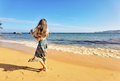 Full length of girl at beach against sky