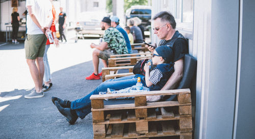 People sitting on street in city