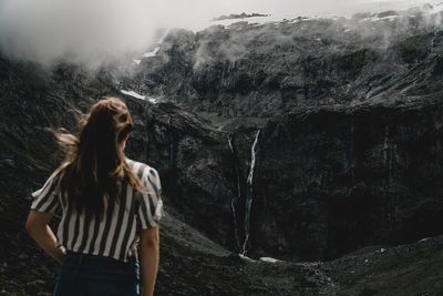 Rear view of woman looking at waterfall