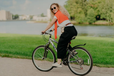 Portrait of young woman with bicycle on road