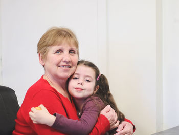 Portrait of a beautiful child girl in the arms of a happy woman.