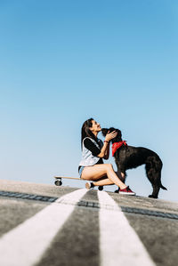 Man with dog against clear sky