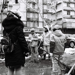 Rear view of people walking on street in city