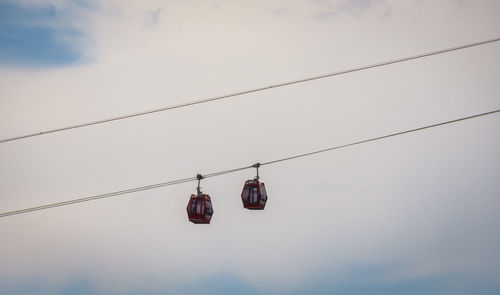 Low angle view of overhead cable hanging against sky