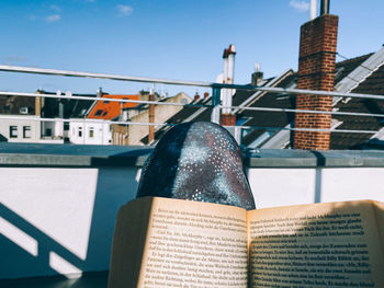 Close-up of book against buildings in city