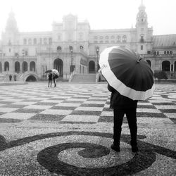 Rear view of woman with umbrella walking in rain