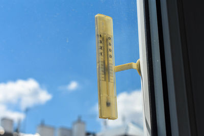 Low angle view of building against blue sky and thermometer