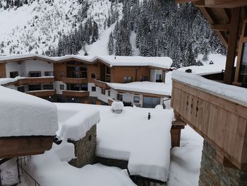 Snow covered houses by buildings during winter