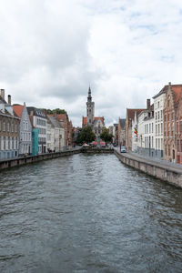 River amidst buildings in city against sky