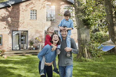 Portrait of happy family in garden of their home