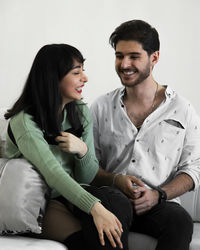 Portrait of young woman sitting on sofa against sky