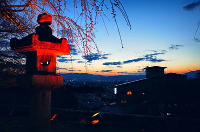 Illuminated building against sky at sunset