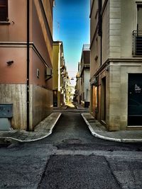 Empty narrow alley along buildings