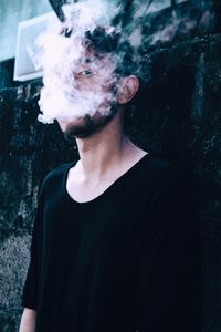 Portrait of young man smoking cigarette