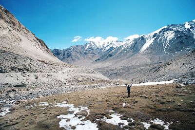 Man on snowcapped mountains against sky