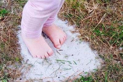 Low section of child standing on field