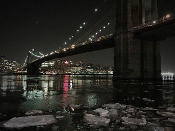 Suspension bridge over river at night