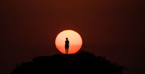 Silhouette man standing against sky during sunset