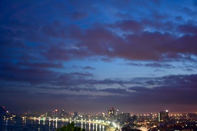 Illuminated cityscape against sky at night