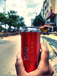 Close-up of hand holding drink in city