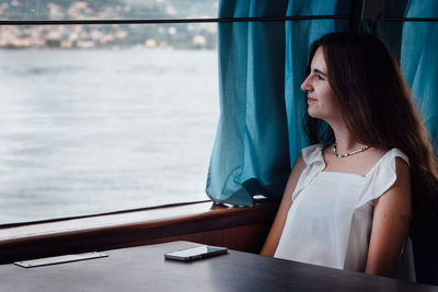 Close-up of young woman sitting in sea