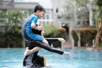 Siblings playing in swimming pool