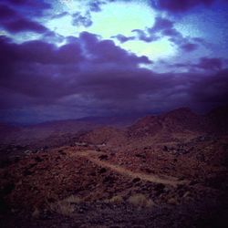 Scenic view of mountains against cloudy sky