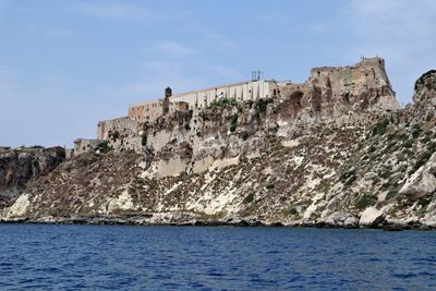 Rock formations by sea against sky