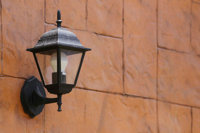 Low angle view of lamp against wall