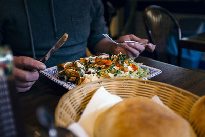 Midsection of man heaving meal at table