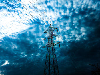 Low angle view of communications tower against cloudy sky