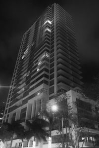 Low angle view of modern building against sky at night