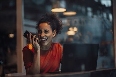 Smiling young woman using mobile phone