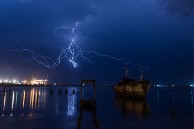 Scenic view of illuminated sea against sky at night