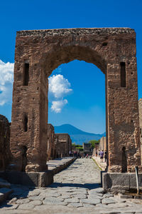 Tourists at the arch of caligula in the ancient city of pompeii