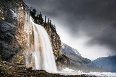 Scenic view of waterfall against sky during winter