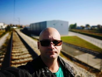 Portrait of man wearing sunglasses at railroad station